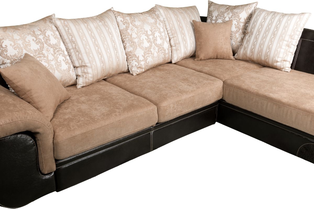 A brown and black sectional couch adorned with decorative pillows, showcasing a modern and cozy living room style. 